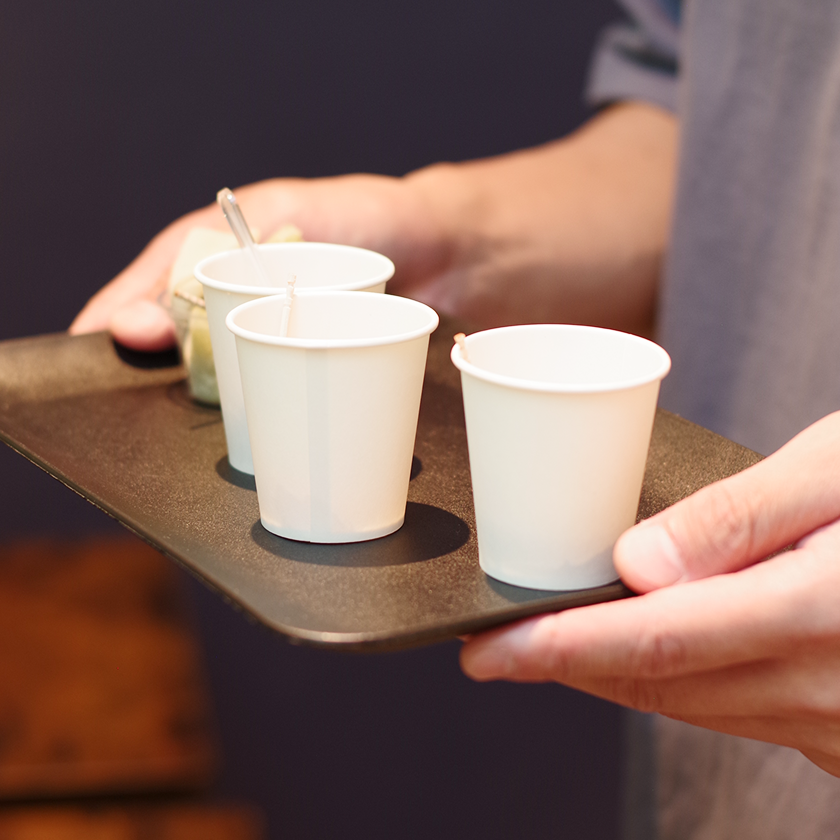 カフェのテーブルでスマートフォンを操作する来店客の手元